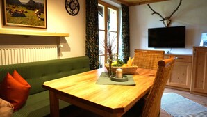 Una sala de estar con un sofá verde, una mesa de madera y un cráneo de venado montado.