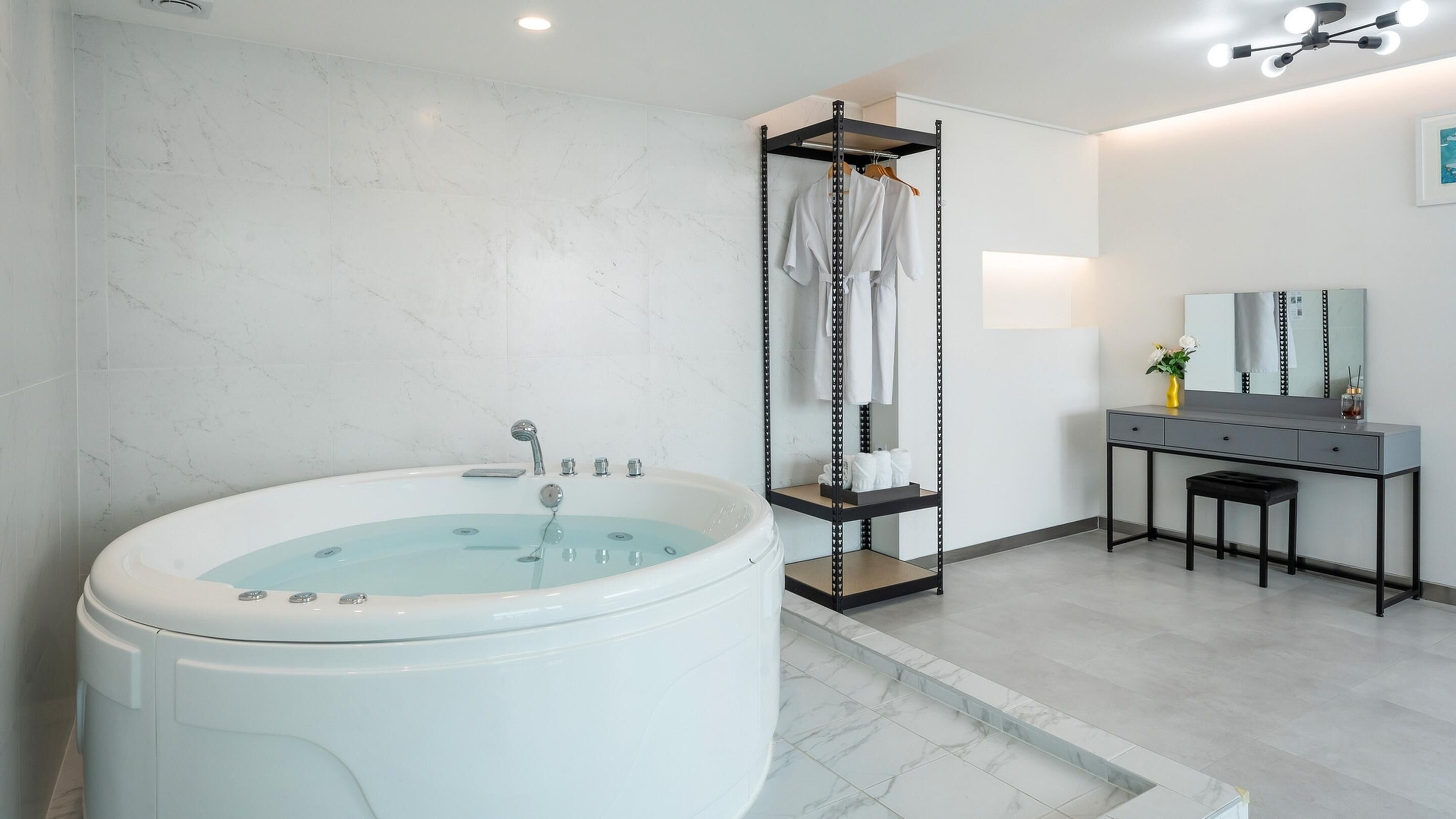 Ein modernes Badezimmer mit einer großen Badewanne, einem Waschtisch inklusive Spiegel und einer Duschkabine.