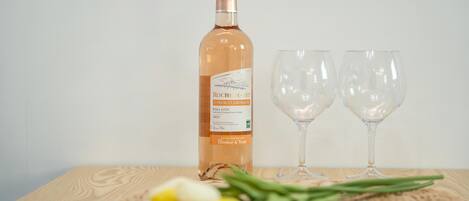 A bottle of wine and two empty wine glasses on a wooden table.