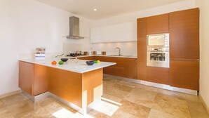A modern kitchen with a central island, built-in oven, and stainless steel appliances. - Seaview Pool Dolmen Apt St Paul's Bay (St. Paul's Bay)