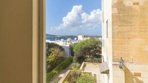 A view from a window overlooking a coastal area with buildings and greenery. - Seaview Pool Dolmen Apt St Paul's Bay (St. Paul's Bay)