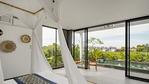 Un dormitorio moderno con cama con dosel, ventanas amplias y vistas a una piscina y vegetación.