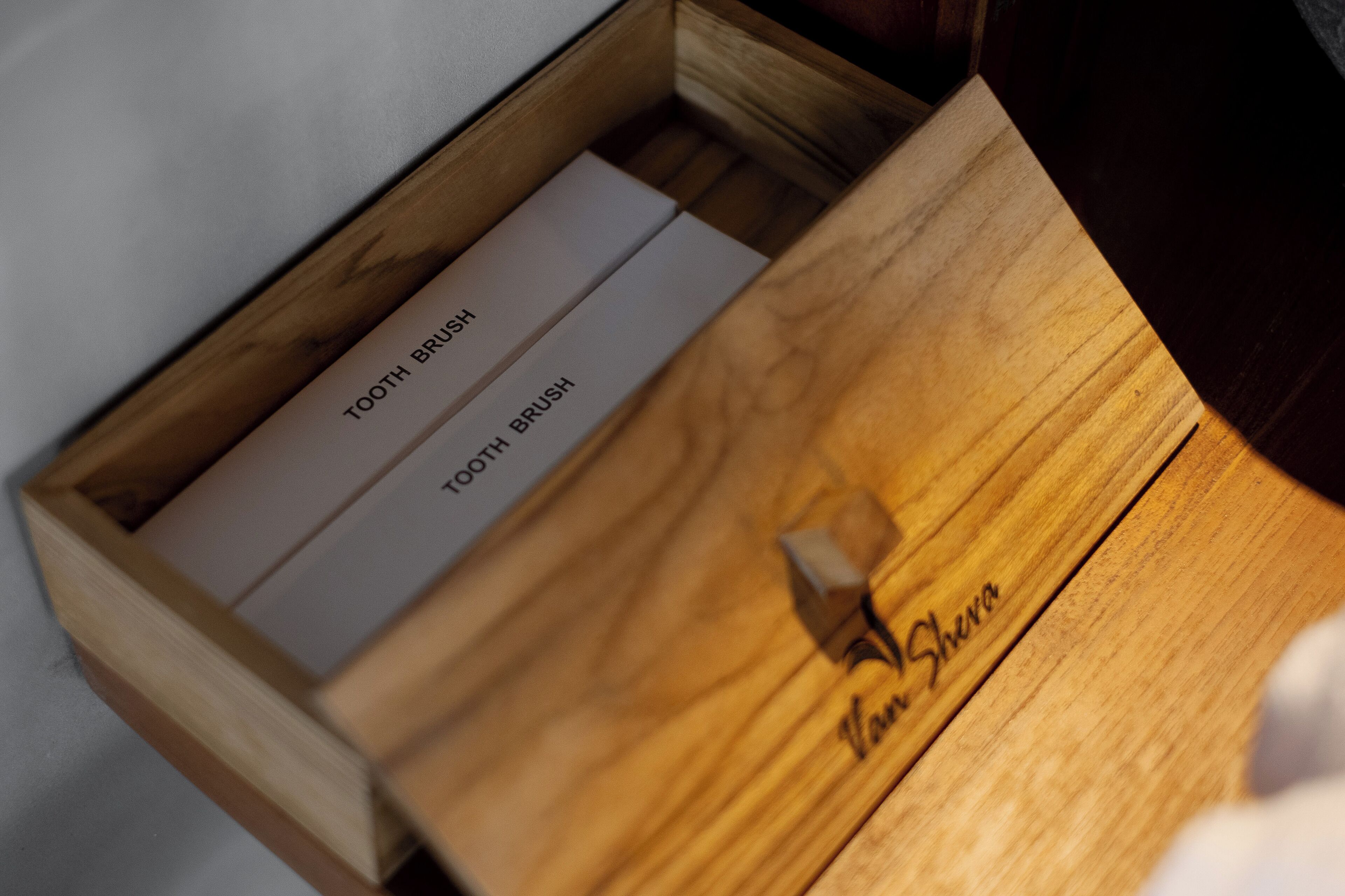 A wooden box with two white boxes labeled "TOOTH BRUSH" inside.