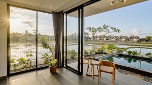Una habitación moderna con ventanas amplias, una piscina pequeña y vistas a una zona residencial.