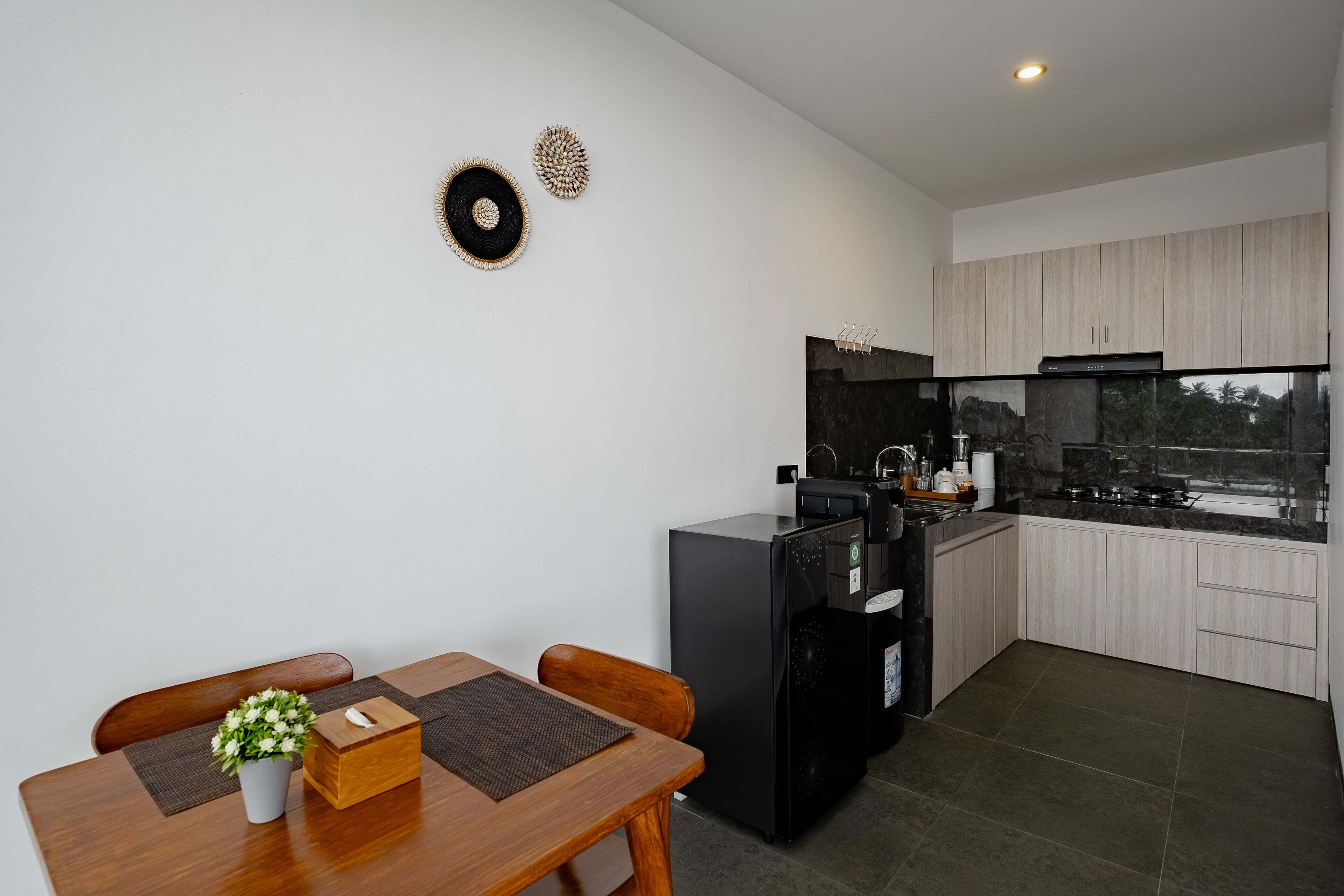 Una cocina moderna con comedor, que incluye un refrigerador, estufa y armarios.