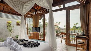 Un dormitorio con cama, televisión y vistas al exterior.