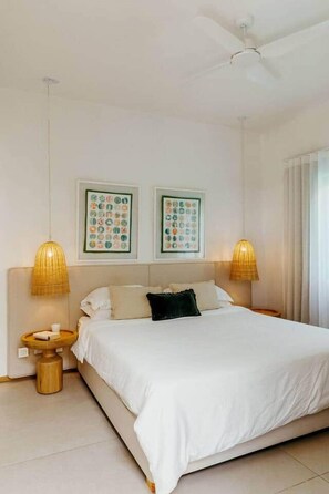 A bedroom with a bed, two wall-mounted lamps, and two framed pictures. - 3 bedroom villa nestled in nature (Black River Gorges)
