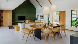 Une cuisine moderne avec un coin repas, des meubles en bois et une grande fenêtre.