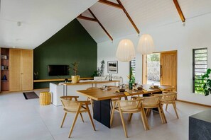 Een moderne keuken met een eethoek, houten meubels en een groot raam.