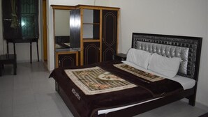 A bedroom with a bed, a wardrobe, and a desk. - Mehran Hotel (Rawalpindi)