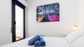 A hotel room with a bed, a window, and a painting of a cityscape with cars. - Atic Cap Tossa by Interhome (Tossa de Mar)