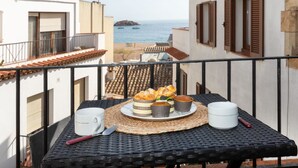 A balcony with a table set for breakfast overlooking the sea. - Atic Cap Tossa by Interhome (Tossa de Mar)