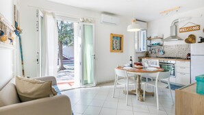 A modern kitchen with a dining area, a sofa, and a view of the outdoors. - Casa e mare by Interhome (Cecina)