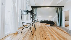 A room with a wooden floor, a bed, a chair, and a table. - Villa Mimi (Sopron)