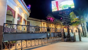 Un resort con un letrero que enumera servicios como habitaciones con aire acondicionado, salón de banquetes, restaurante y spa.