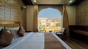 Una habitación de hotel con cama, escritorio y vistas a la ciudad.