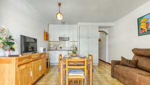 Un ambiente compatto con angolo cottura, zona pranzo e soggiorno.