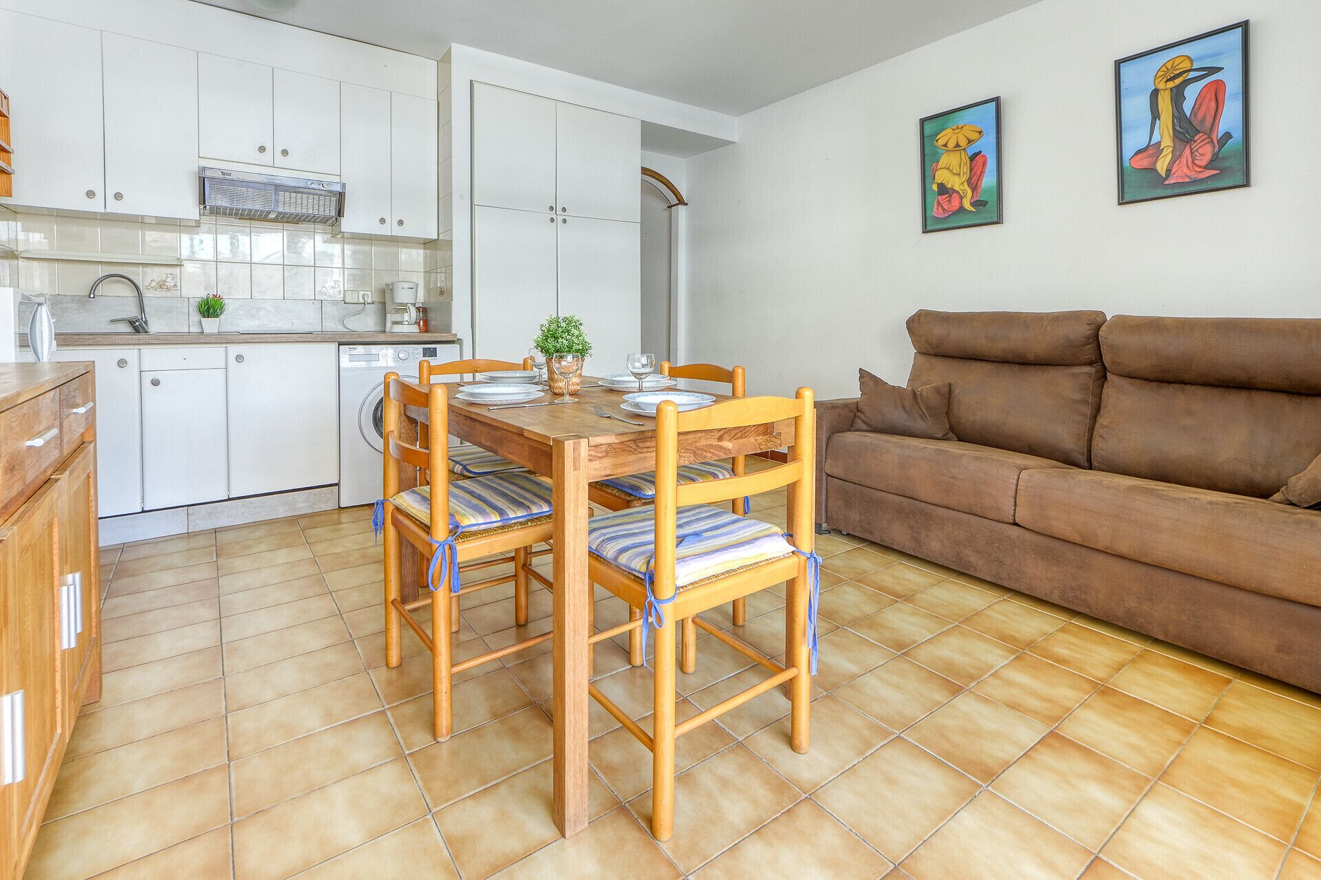 A compact living space with a kitchenette, dining area, and a sofa.
