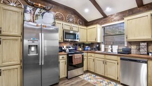 A kitchen with wooden cabinets, stainless steel appliances, a microwave, and a dishwasher.