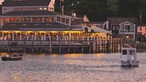 A waterfront restaurant with outdoor seating, a dock, and a boat. - Oceanfront home w/Amazing Views, Hottub! Sleeps 10 (Scituate)