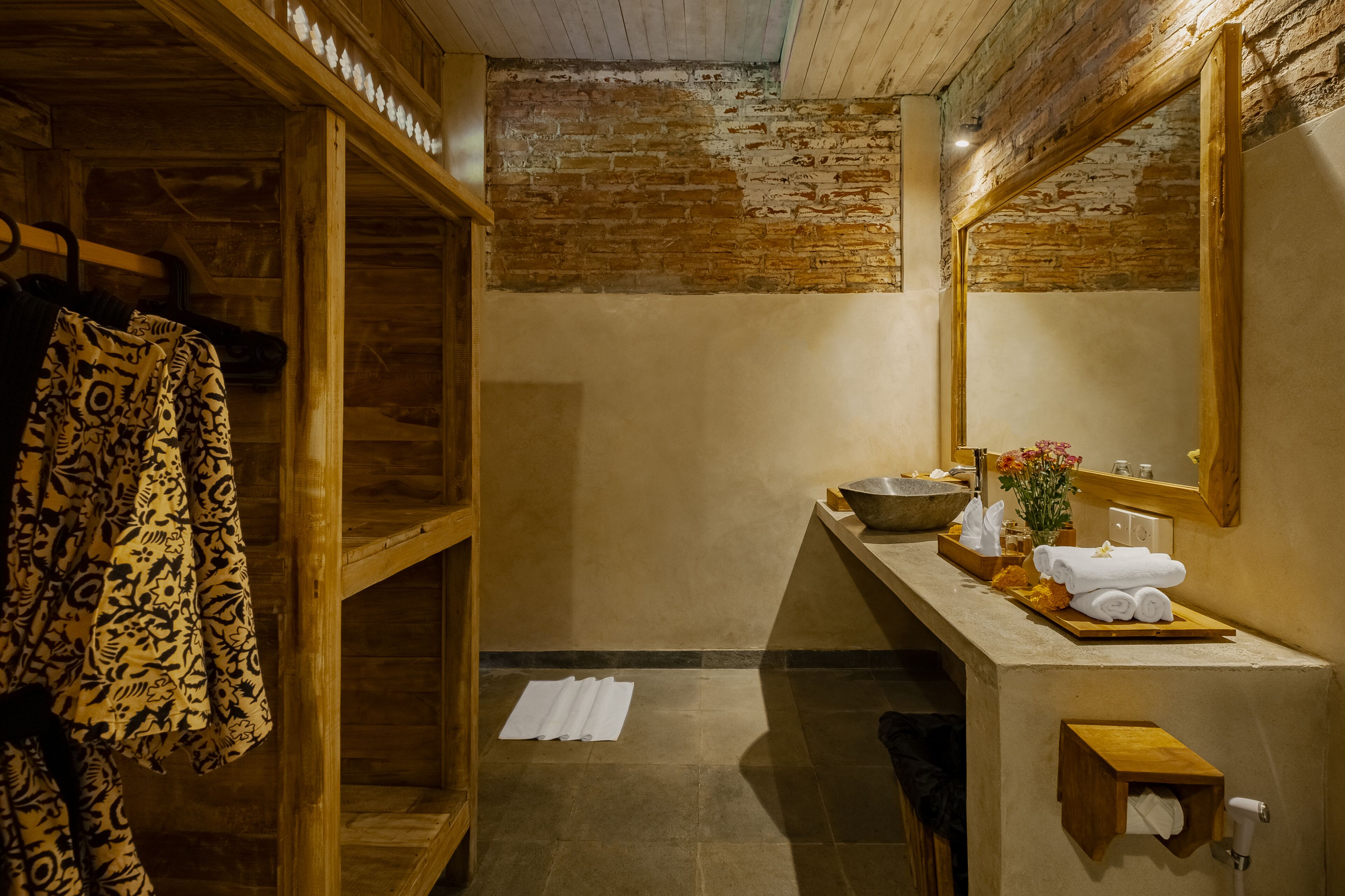 A wooden interior with a stone sink, towel rack, and a mirror.