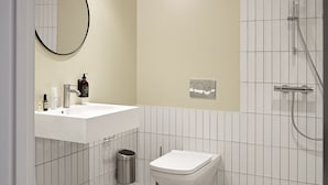 A modern bathroom with a white sink, a toilet, a mirror, and a shower. - One Bedroom Apartment for 4 in Inner Courtyard (København)