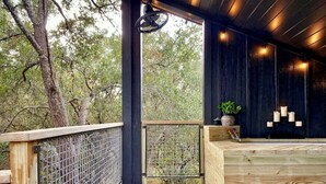 Une terrasse en bois avec une clôture en métal, un comptoir d’accueil en bois et un sol carrelé à motifs.