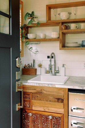 A kitchen with a wooden cabinet, a sink, and a countertop.