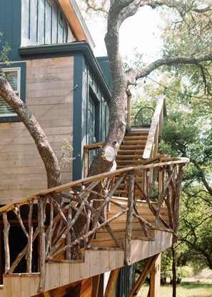 Une terrasse en bois avec un escalier menant à une maison à l’extérieur bleu foncé.