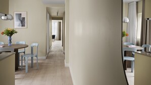 A modern hotel room with a dining area, a large mirror, and a hallway leading to another room. - One-Bedroom Apartment for 6 with Open Plan (København)