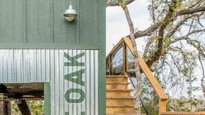 A wooden staircase leading to a green building with a sign that reads "LIVE OAK".