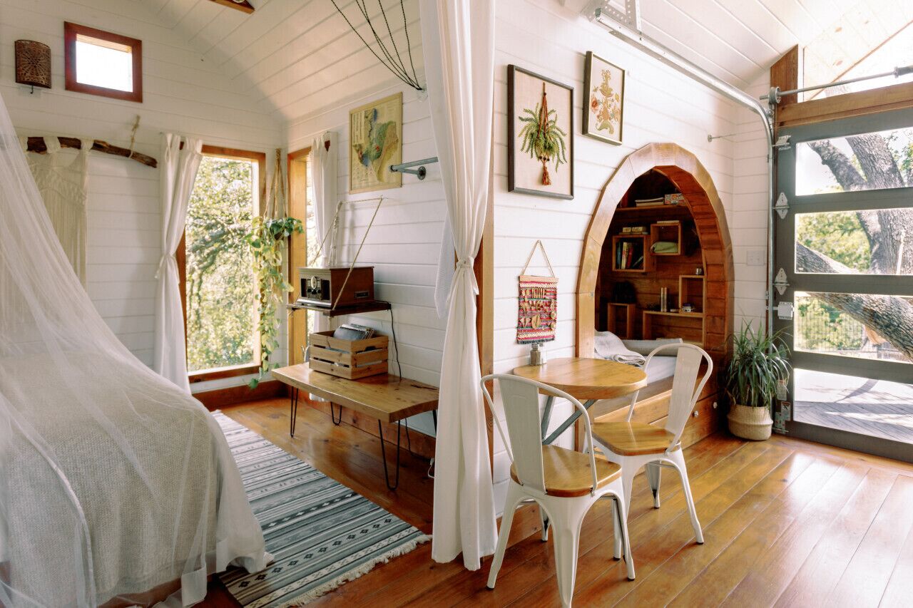 Una habitación acogedora con una cama, un escritorio, una silla y una estantería.