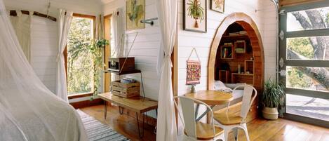 Una habitación acogedora con una cama, un escritorio, una silla y una estantería.