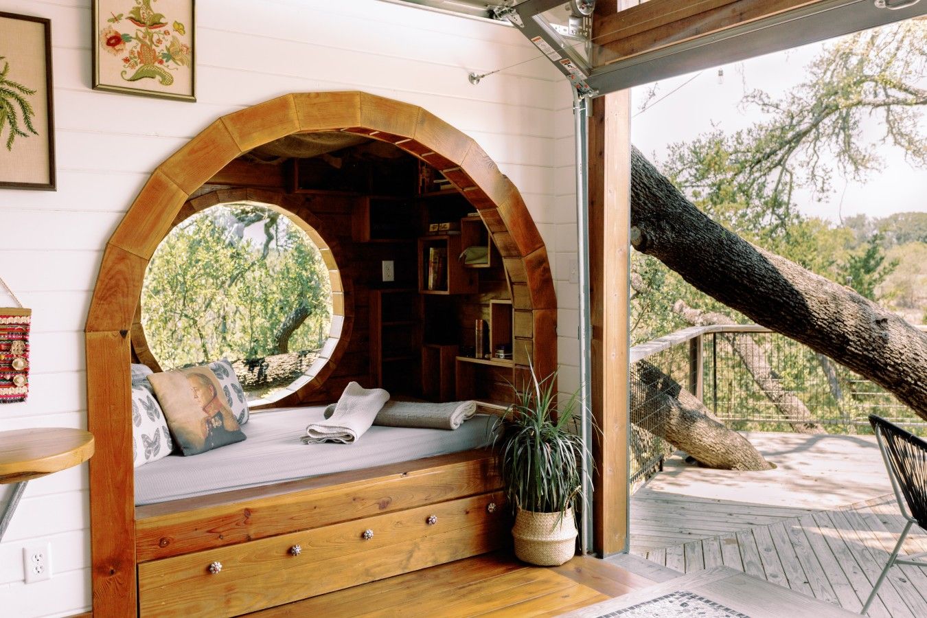 A cozy reading nook with a circular window, wooden bookshelves, and a bench.