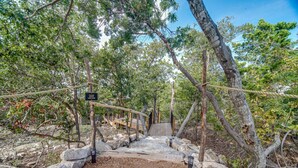 Eine Holzbrücke mit einem Schild, umgeben von Bäumen und Felsen.
