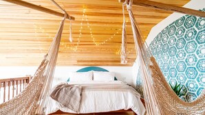 Una cama hamaca con techo de madera y pared con diseño.