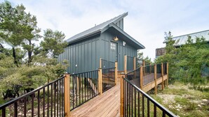 Un bâtiment moderne doté d’un toit en pente, d’une terrasse en bois et de rampes en métal.