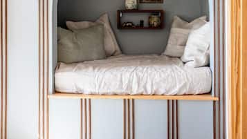 A cozy reading nook with a curved bench, a small shelf with books, and string lights.