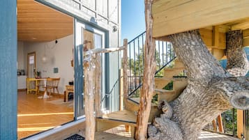 A wooden staircase leading to a balcony with a view of the interior of a building.