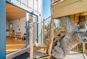 Un escalier en bois menant à un balcon d’où l’on peut admirer l’intérieur d’un bâtiment.