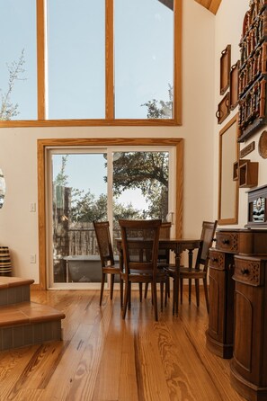 A dining area with wooden furniture, a large window, and a view of the outdoors. - Blue Sage No. 9 - The Stairway to Heaven (Fredericksburg)