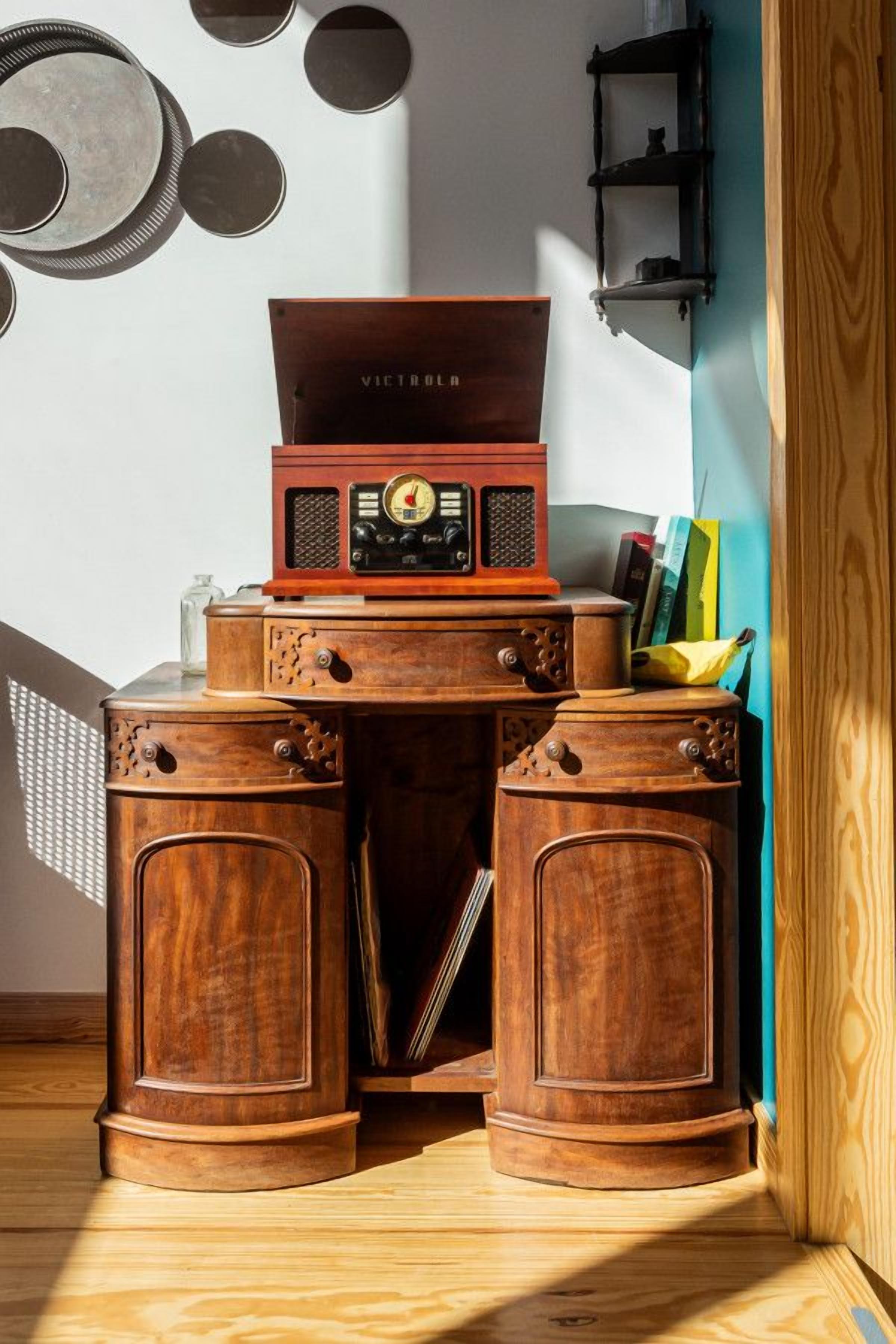 Un escritorio de madera con una radio antigua y libros.