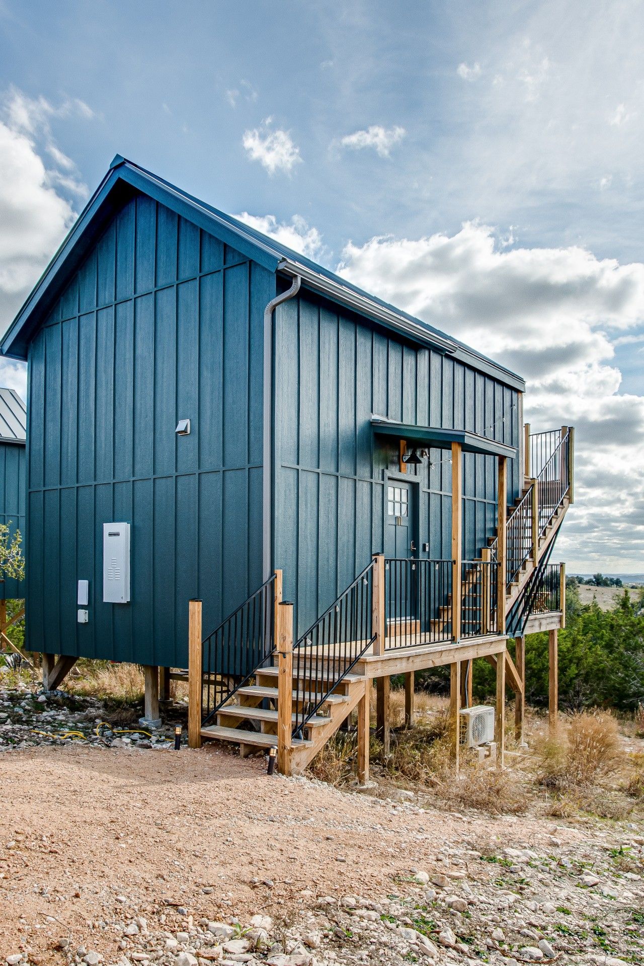 A building with a wooden deck and stairs leading to a door.
