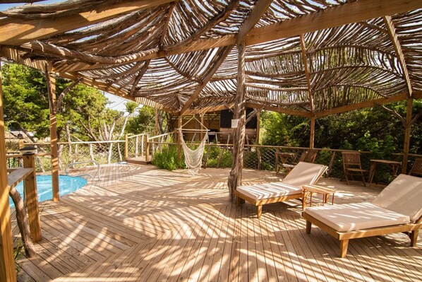 A wooden deck with a pool, lounge chairs, and a hammock. - Blue Sage No. 11 - The Rooftop Stargazer (Fredericksburg)
