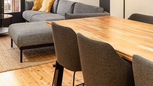 A modern living room with a grey sofa, a wooden dining table, and a floor lamp. - Vista: Spacious city centre home (Thessaloniki)