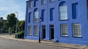 A blue building with multiple windows and a door.