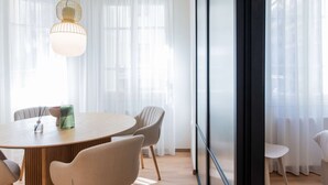 Un espace repas moderne avec une table ronde, des chaises et un luminaire suspendu.