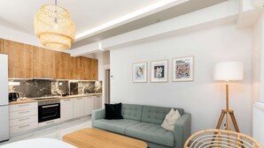 Eine moderne Küche mit Holzschränken, einer Marmor-Spritzschutzleiste und einem Essbereich mit Holztisch und Korbstuhl.