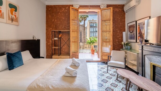 Ein Hotelzimmer mit Bett, Schreibtisch, Stuhl, Kamin und Blick ins Freie.