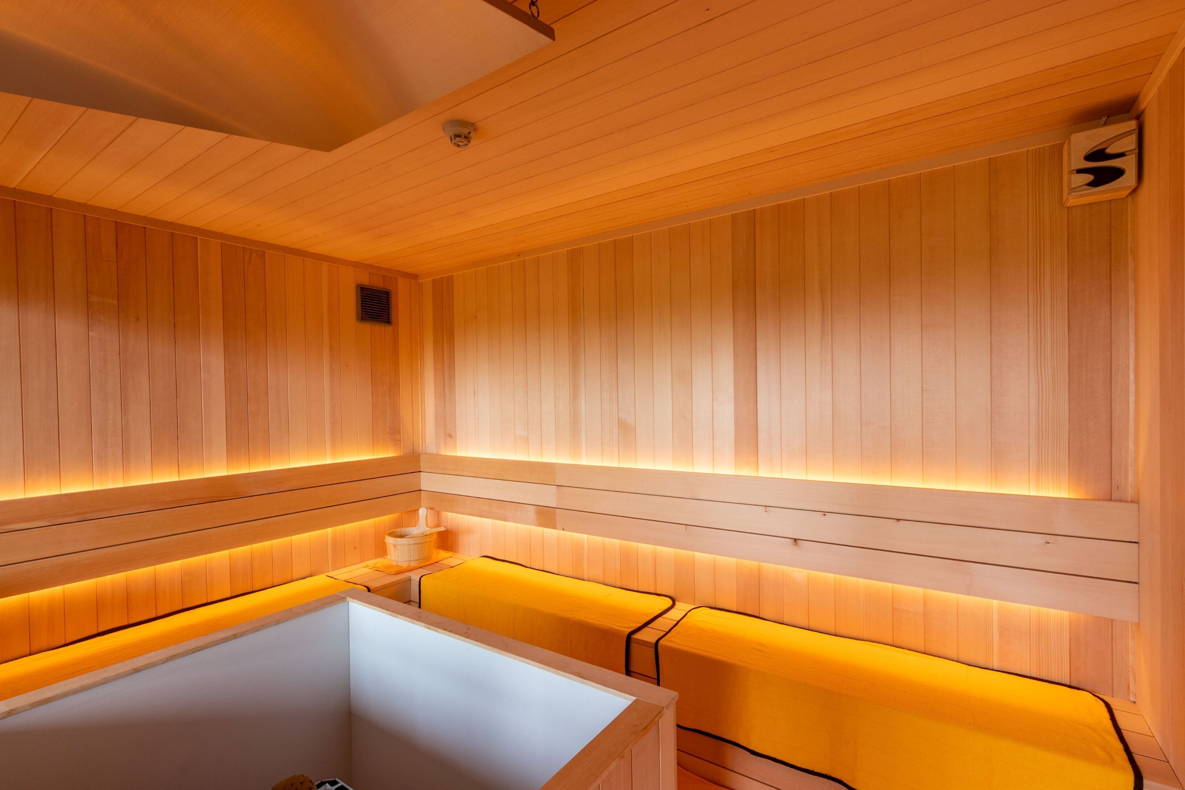 A wooden interior with benches and a bathtub.